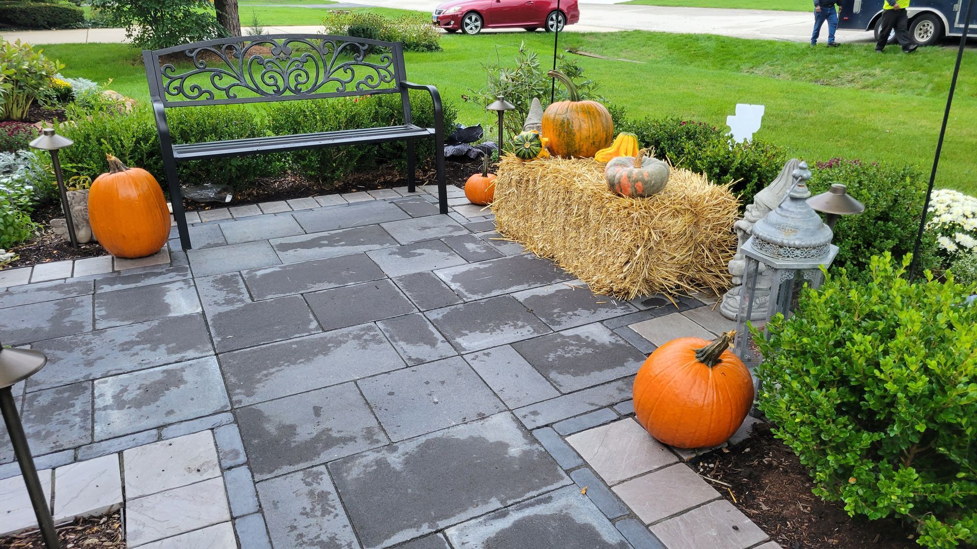 A patio with pumpkins and hay bales on it