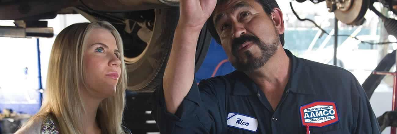 AAMCO service expert and customer checking under car