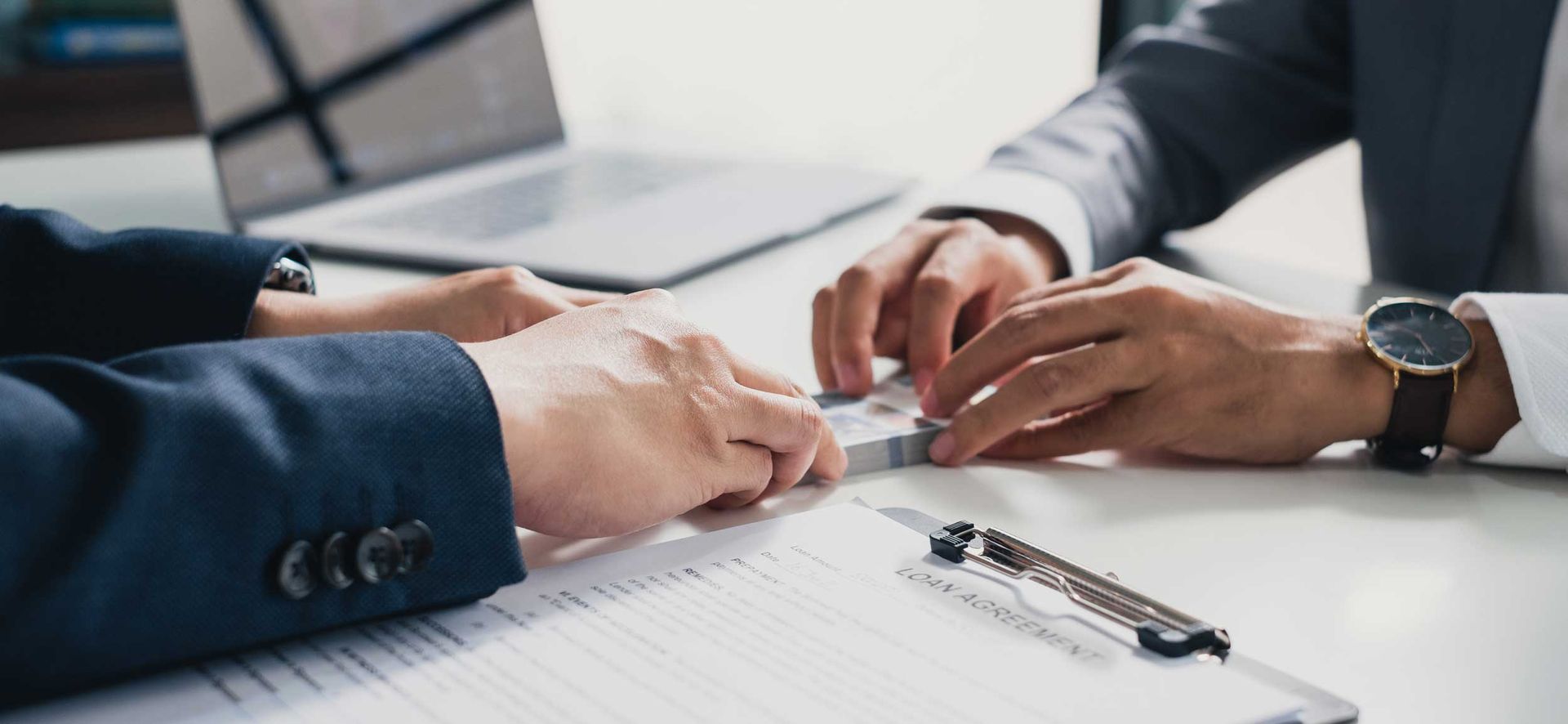 Close-up hands of a loaner giving cash loan solutions to another person. Close-up hands of a loaner giving cash loan solutions to another person.