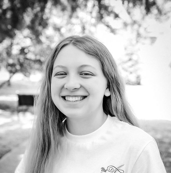 Smiling young woman with long hair wearing a t-shirt, outdoors.