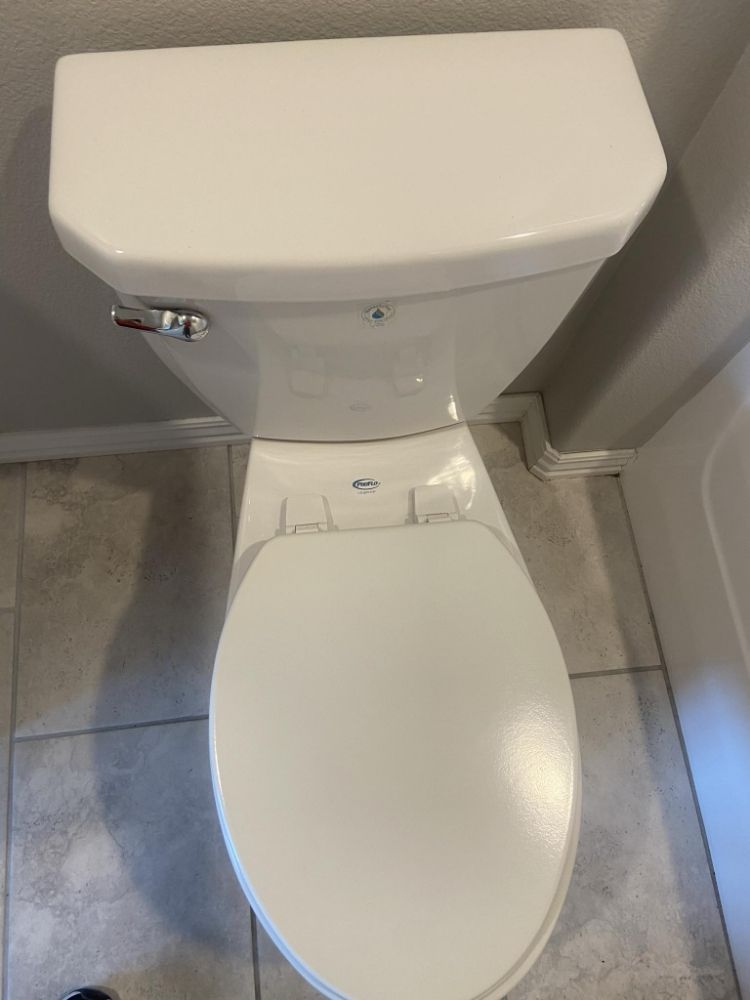 A white toilet is sitting on a tiled floor in a bathroom — Springdale, AR — Lady Bug Cleaning Services