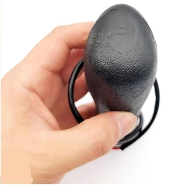 Mano sosteniendo un pequeño dispositivo negro texturizado con clip y un cable en bucle.