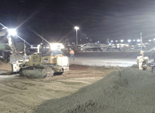 Eine Baustelle bei Nacht mit einem Bulldozer und einem Erdhaufen.