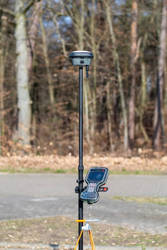 Ein GPS-Gerät sitzt oben auf einem Mast neben einer Handyhalterung.