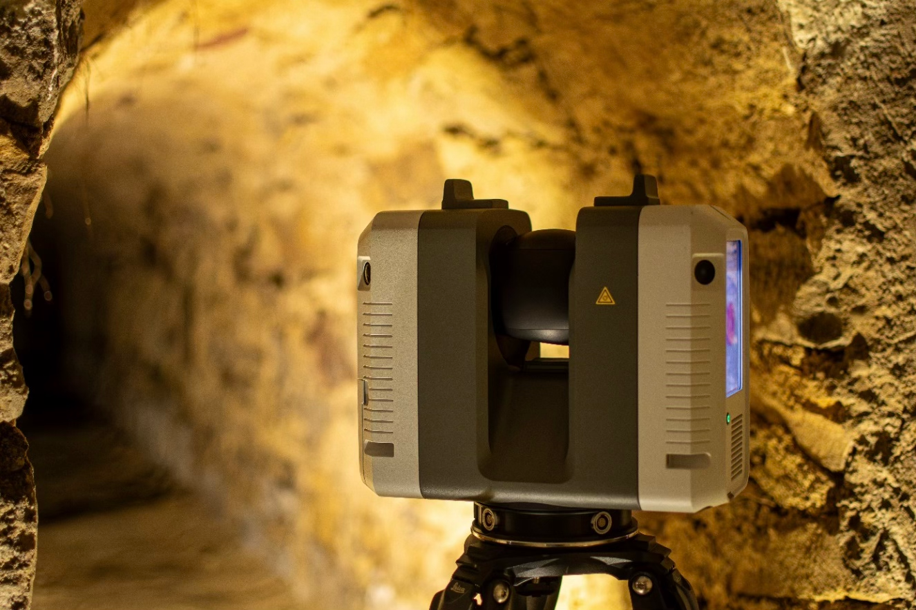 Ein 3D-Scanner steht auf einem Stativ in einer Höhle.