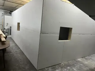 Drywall structure with two square openings. Construction in a workshop setting.