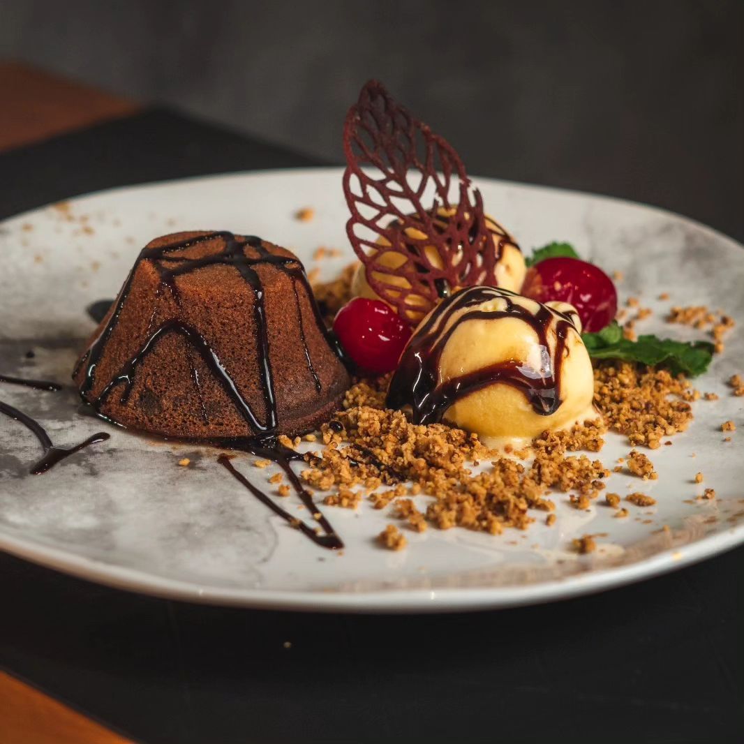 Um prato branco coberto com bolo de chocolate e sorvete