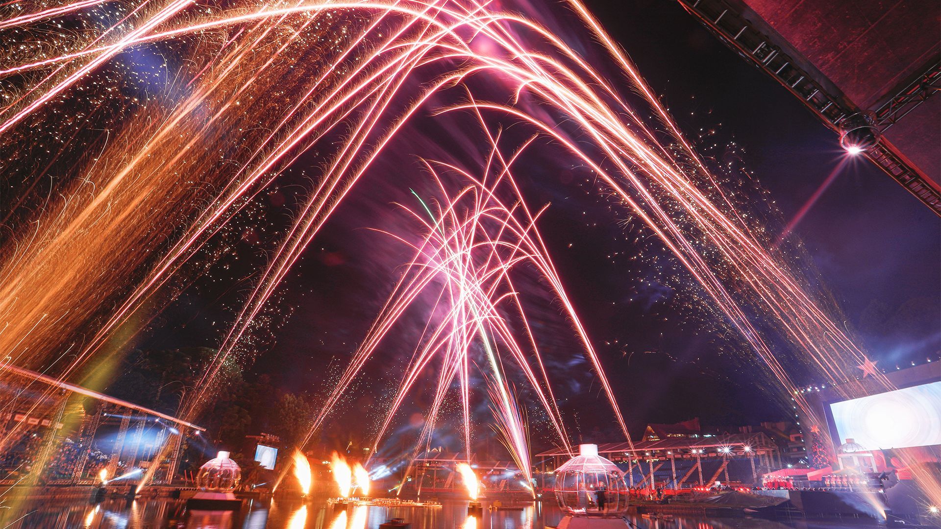 Um monte de fogos de artifício estão explodindo no céu noturno