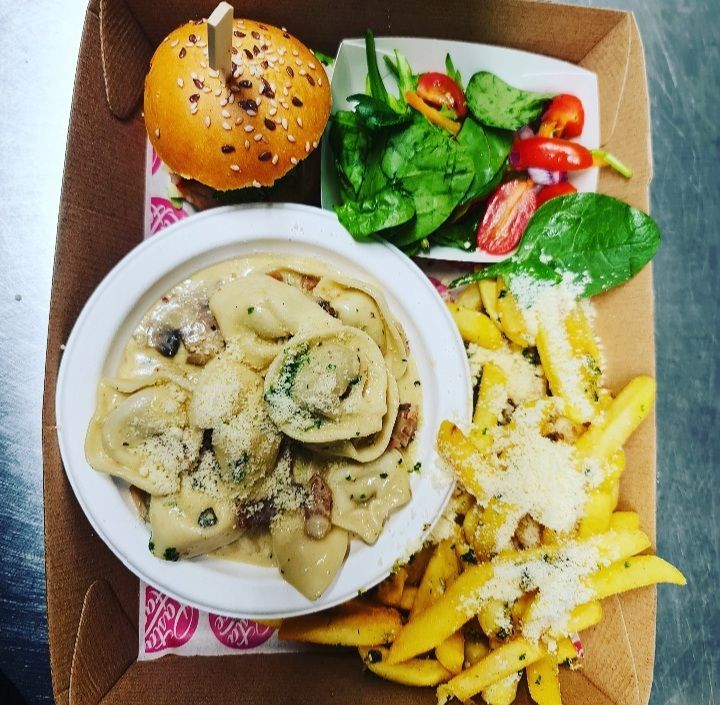 A cardboard box filled with food including french fries and a hamburger
