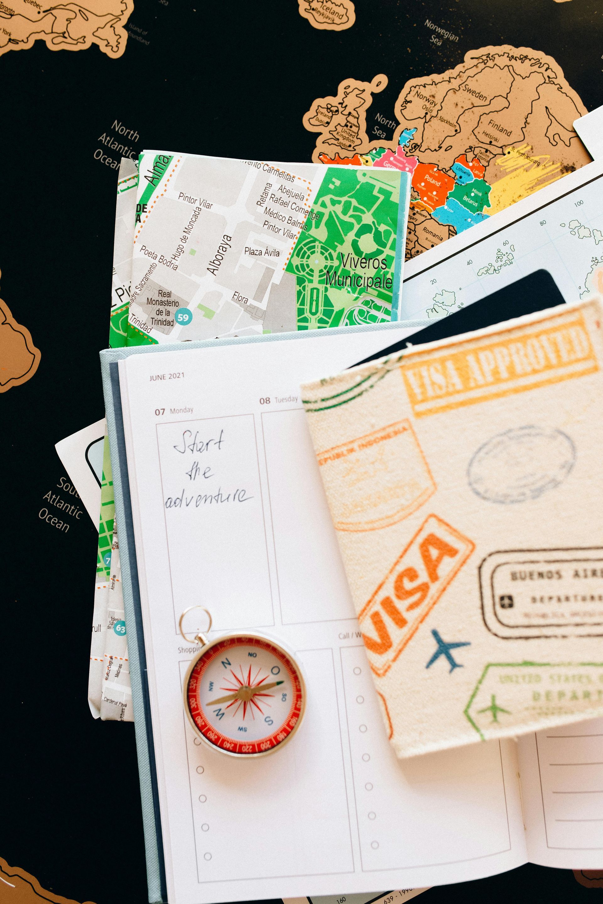 A compass and a passport with visa stamps on it