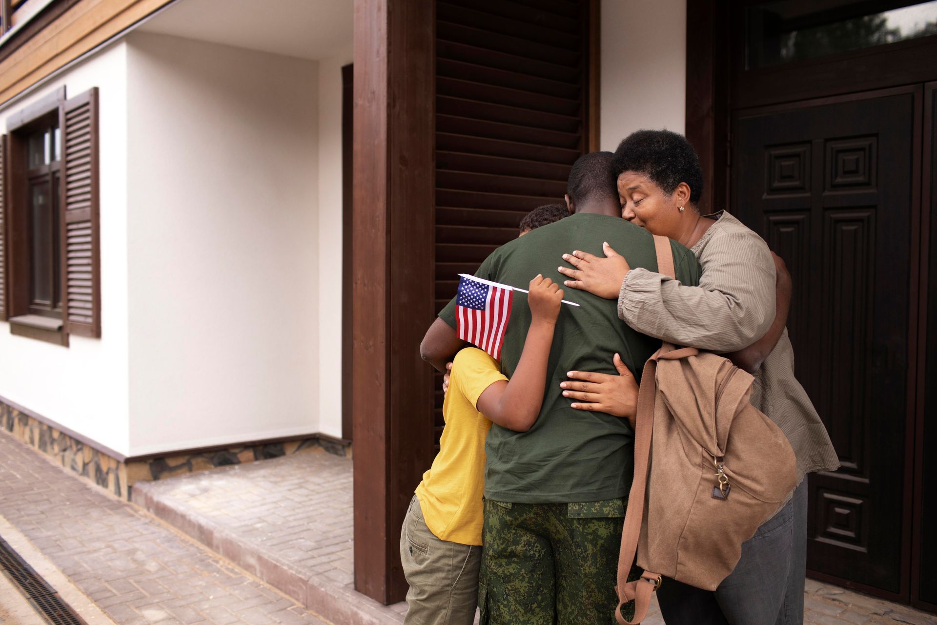 A woman is hugging a man with an american flag on his back