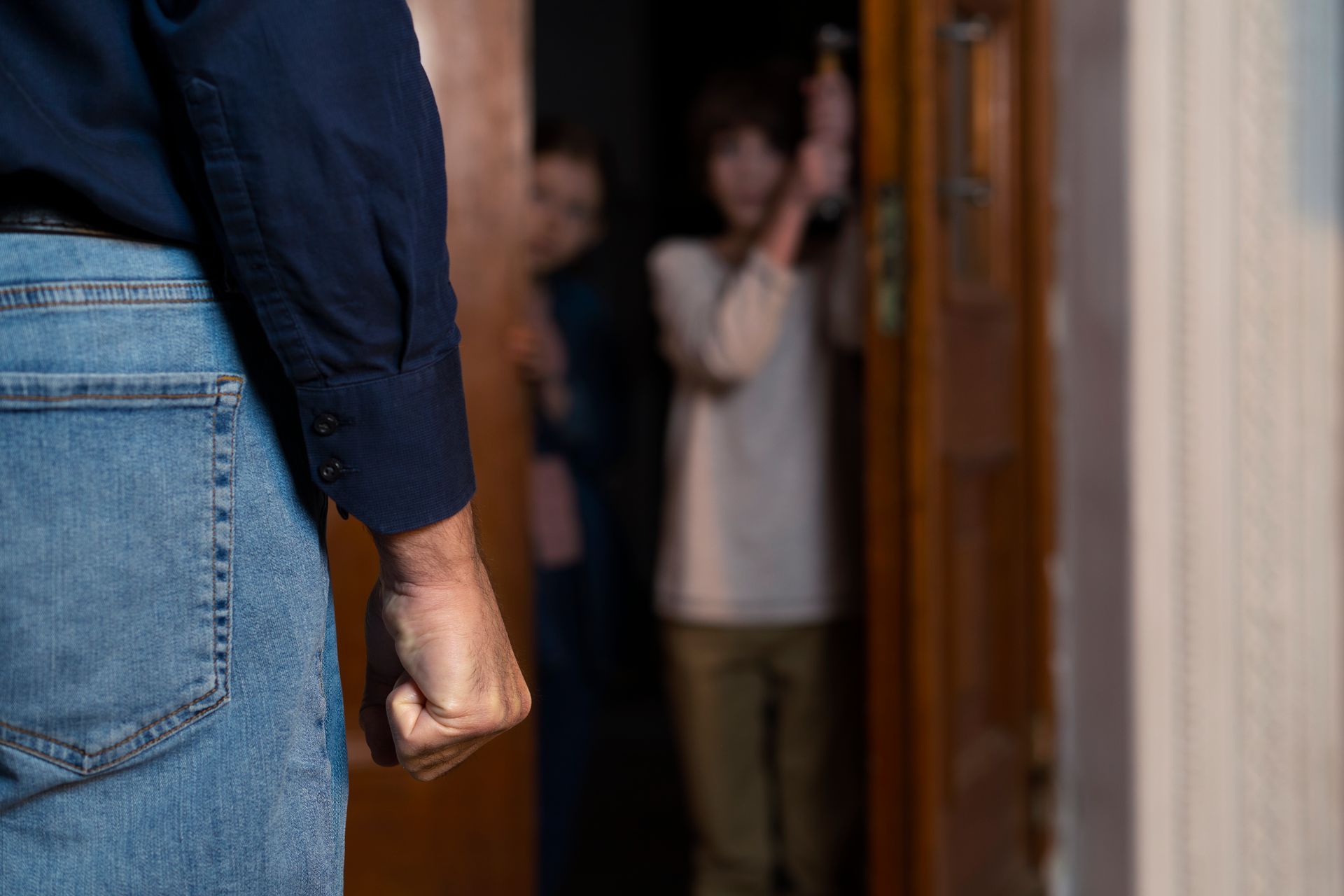 A man is standing in front of a door with his fist in the air.