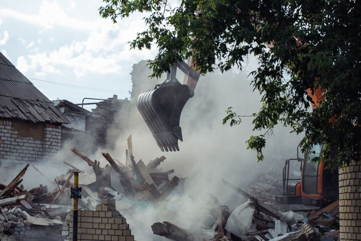 A man and a woman are looking at a blueprint on a construction site.