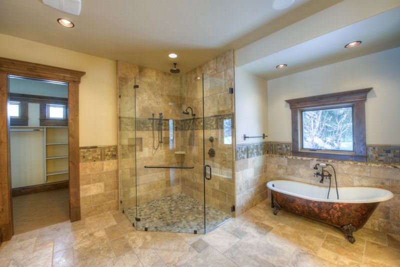 A bathroom with a tub , shower , and walk in closet.
