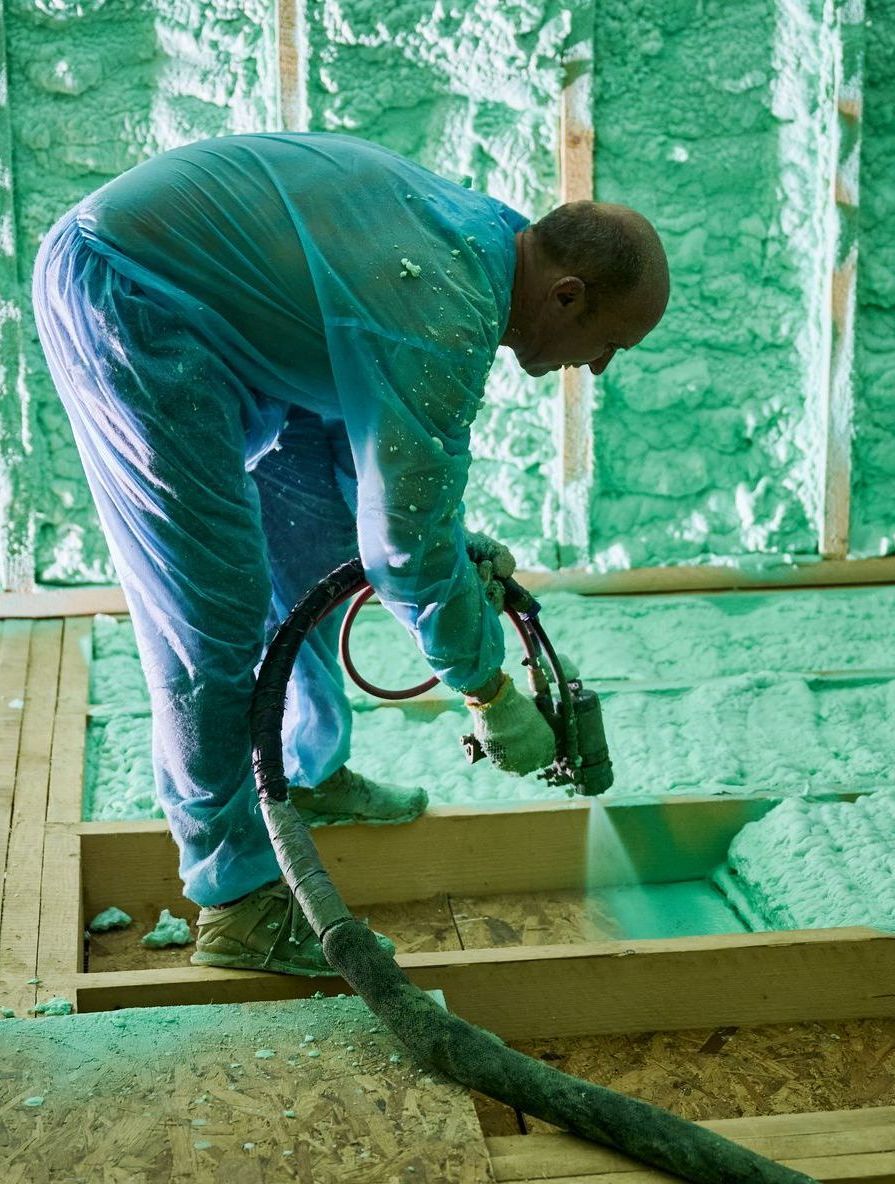 Spray Foam Insulation Contractor in Burlington spraying foam into attic floor