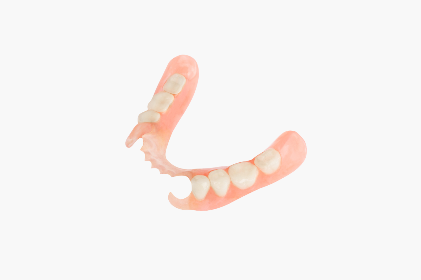 Partial denture, pink with white teeth, isolated on white background.