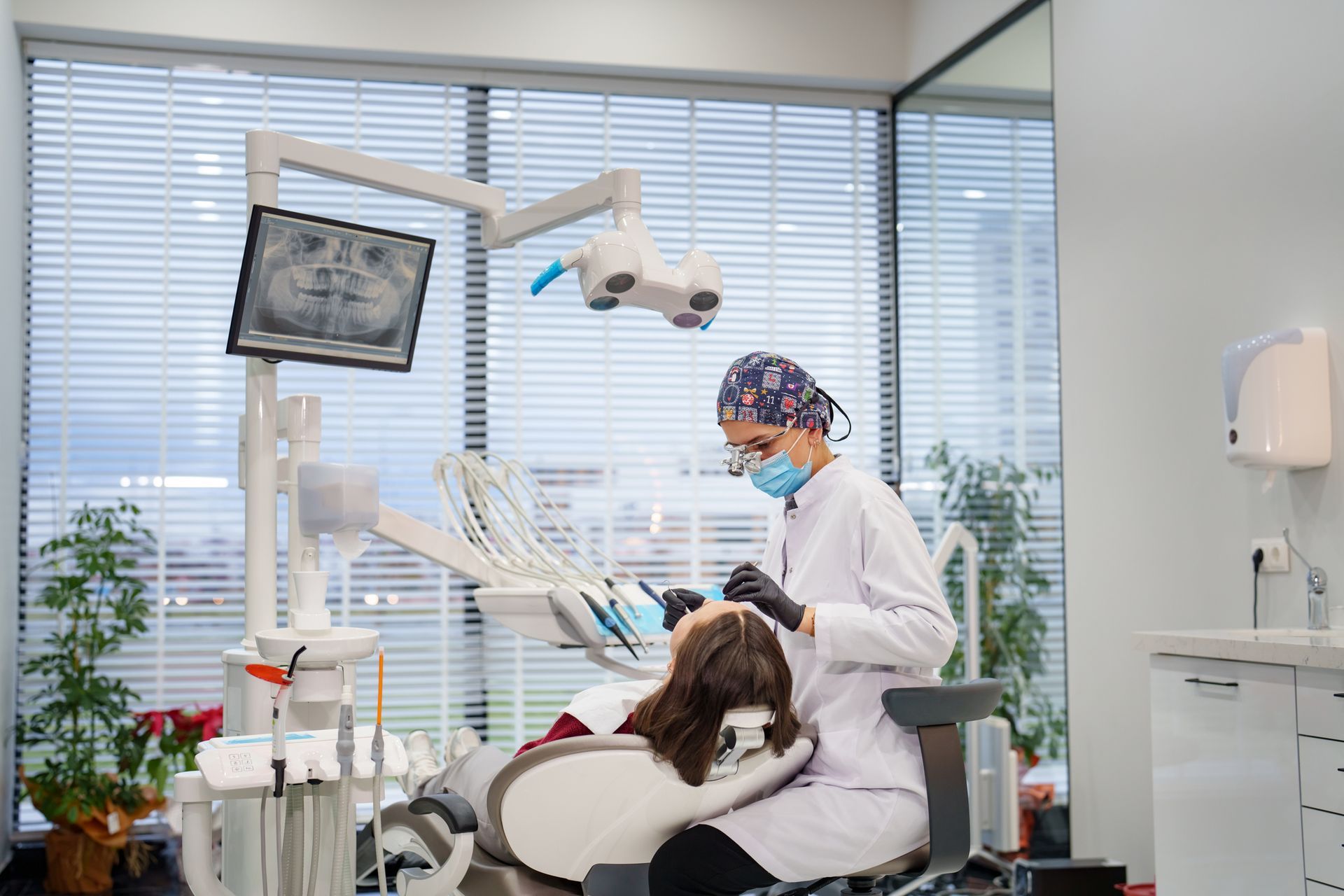 A dentist is examining a patient 's teeth in a dental office.