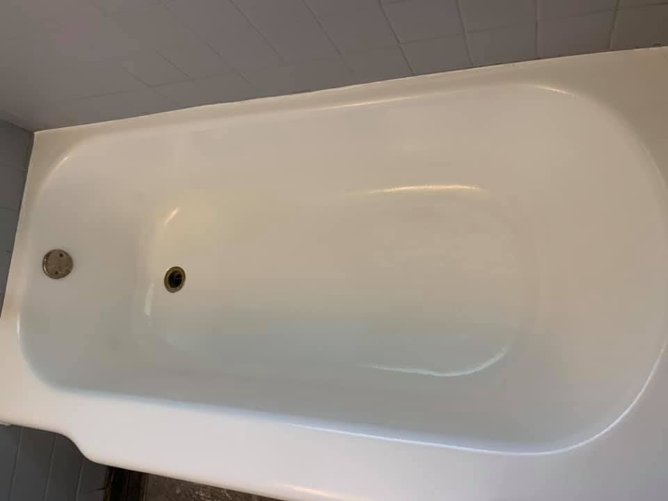 White bathtub with drain and overflow holes.