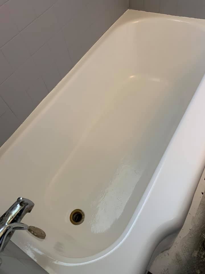 White bathtub with faucet and drain.