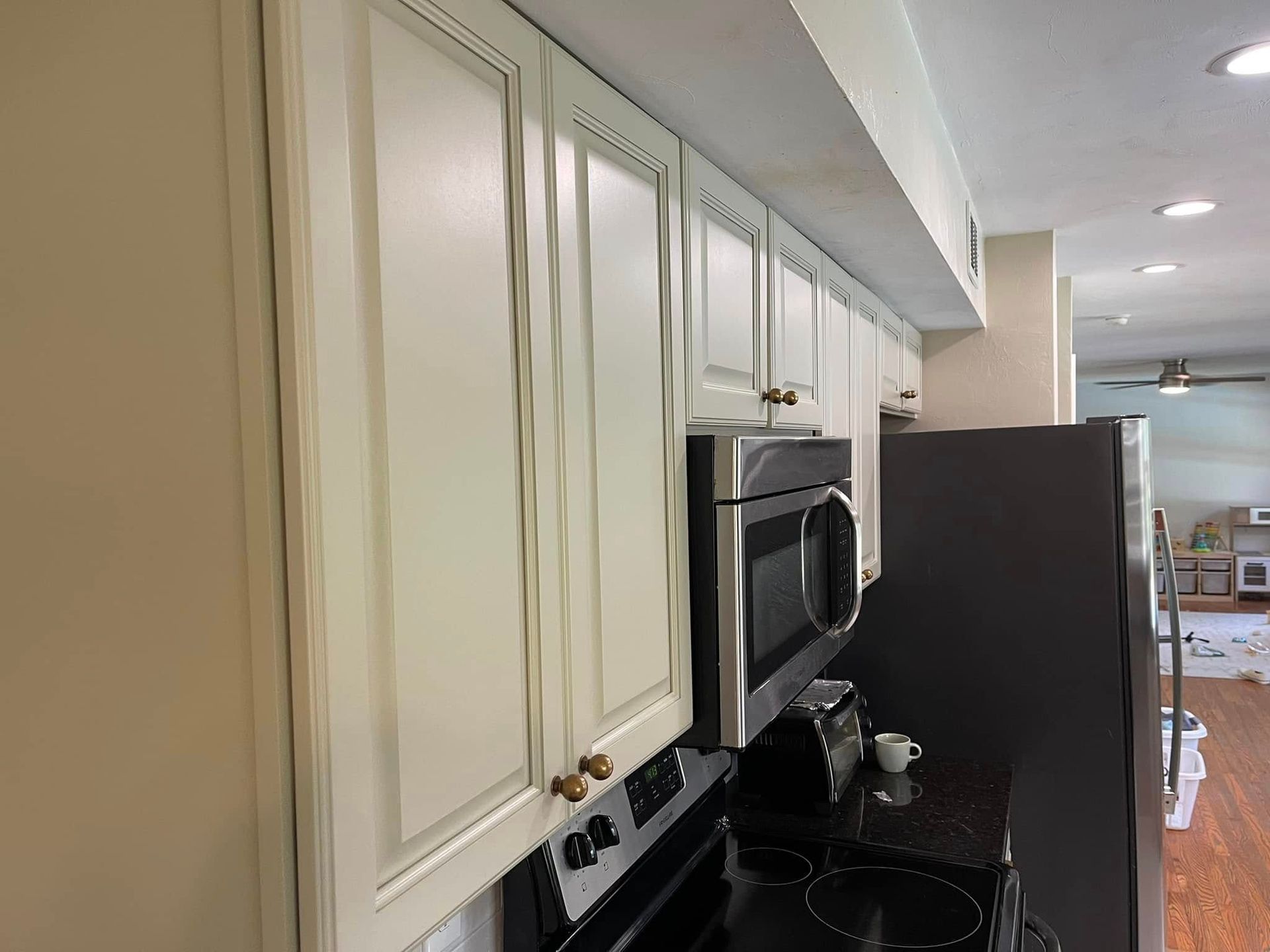 Cream-colored kitchen cabinets and appliances against a wall.