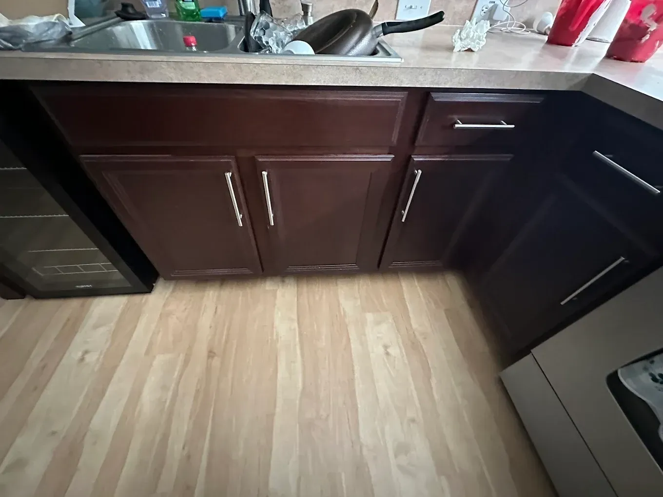 Kitchen cabinets and appliances with wood flooring.