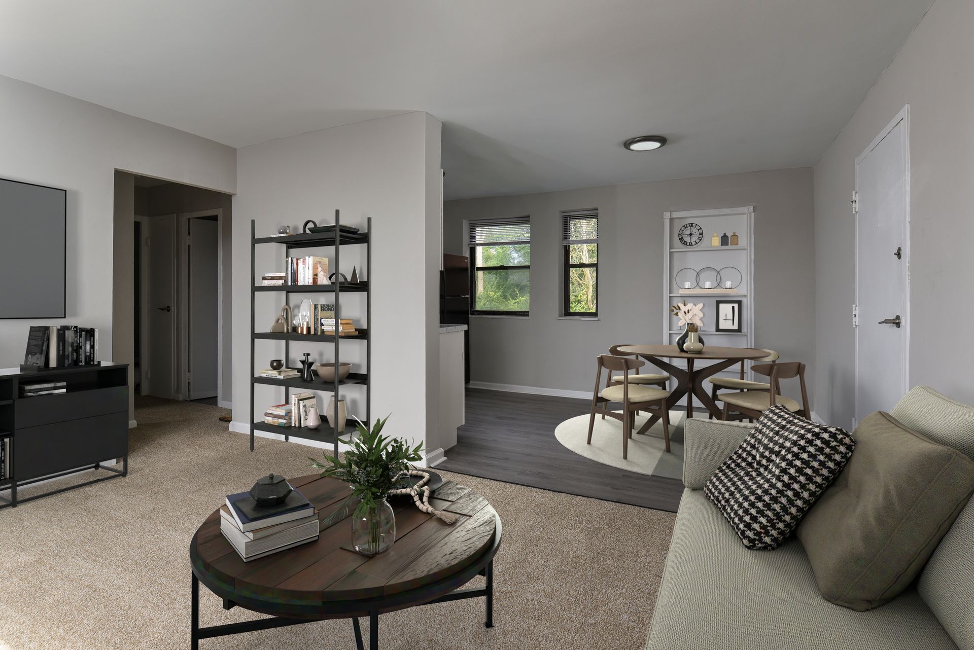 Living room with beige carpet, gray walls, open to dining area with round table and chairs.