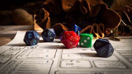 Dice on a character sheet with a brown pouch in the background, ready for a tabletop game.
