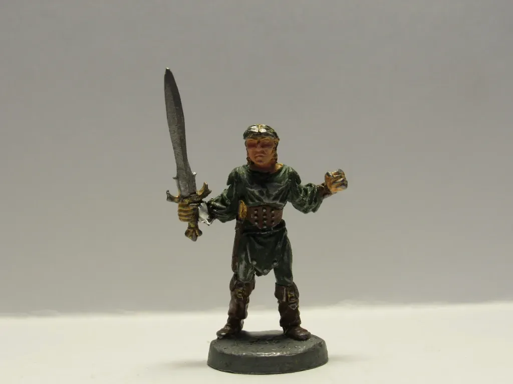 Miniature figure of a man in green tunic wielding a sword.