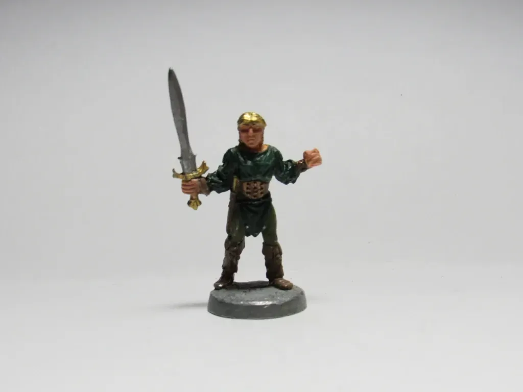 Miniature figure of a warrior with a sword and helmet, posed against a white background.