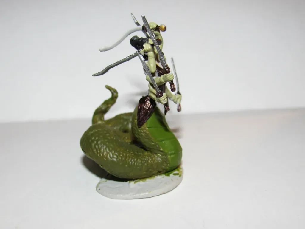 Miniature figure: a soldier on a green snake, in a combat pose, on a white surface.