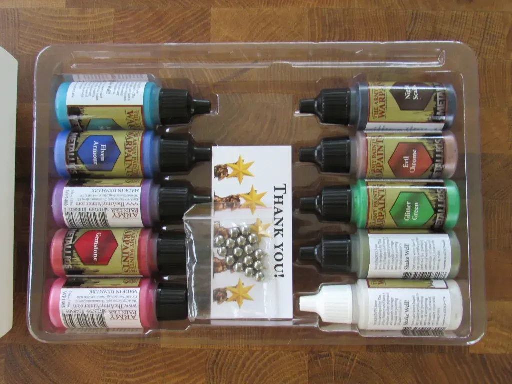 A tray of colorful inks, including metallic, with mixing balls and a