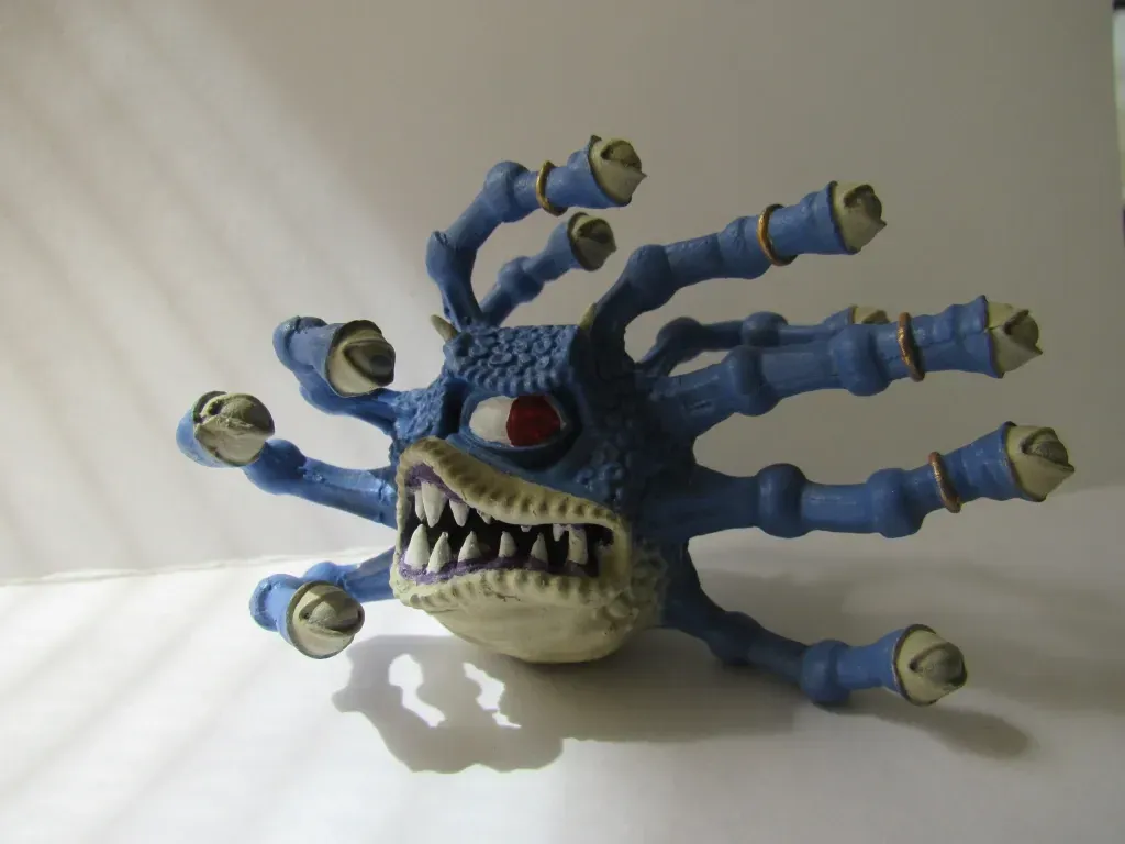 Blue monster with many eye stalks, a wide mouth, and one large red eye.
