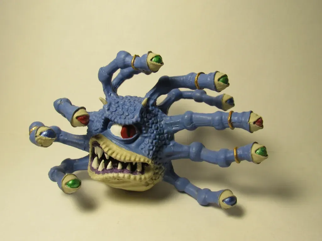 Blue, toy creature with multiple eye stalks, open mouth with sharp teeth.