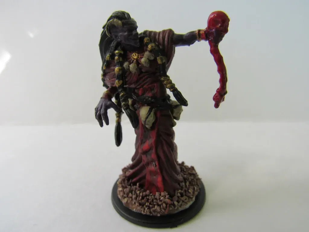 Miniature of a robed, purple-skinned figure holding a bloody tendril. It has dreadlocks and is on a base.