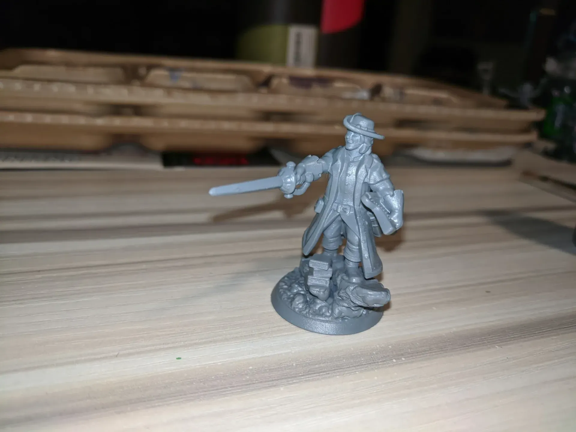 Miniature figure of a man holding a sword and shield, standing on a rocky base.