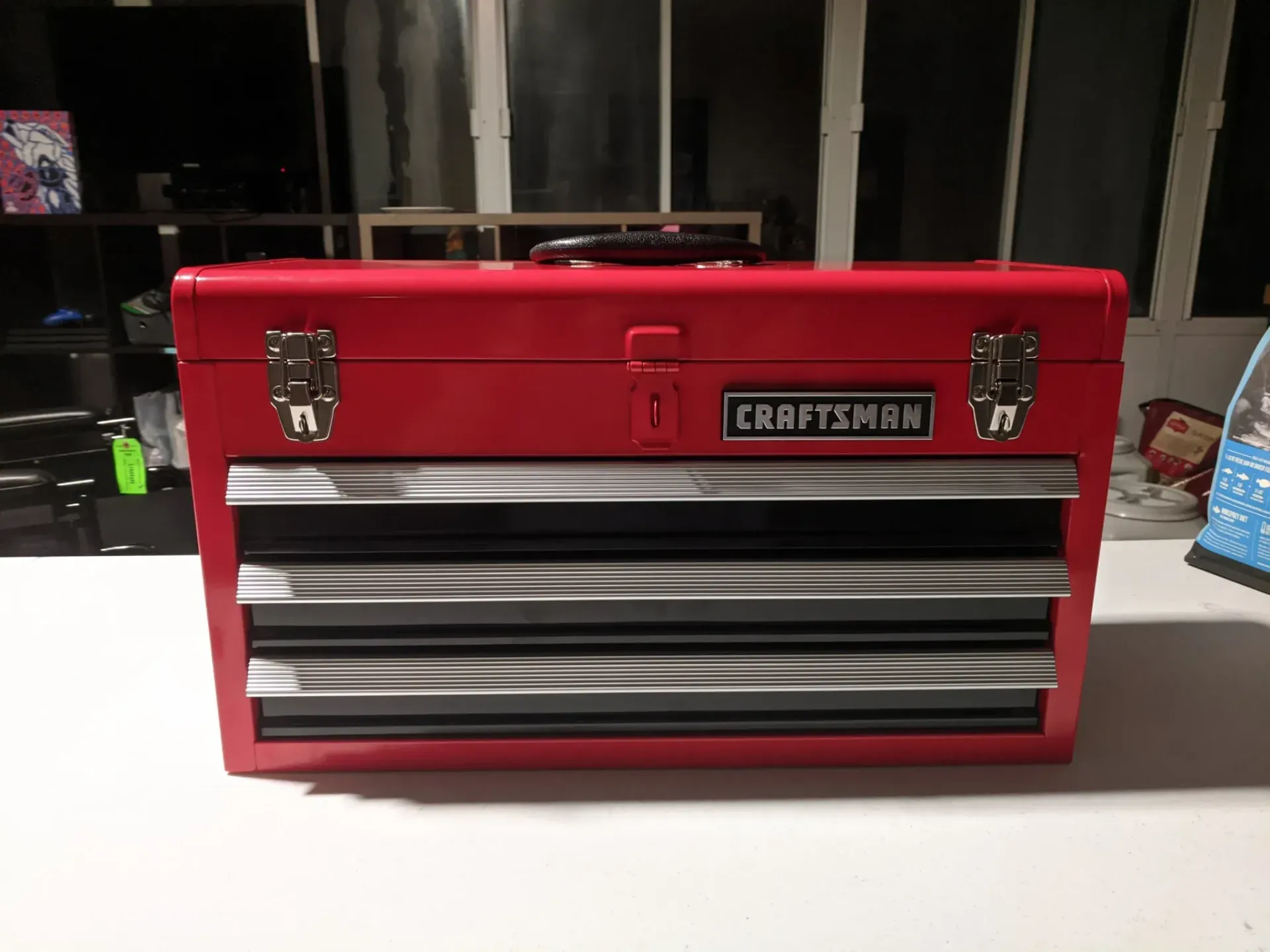 Red Craftsman toolbox with silver drawers on a white surface.