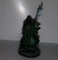 Green robed wizard figure with staff emitting blue flames, on a round base.