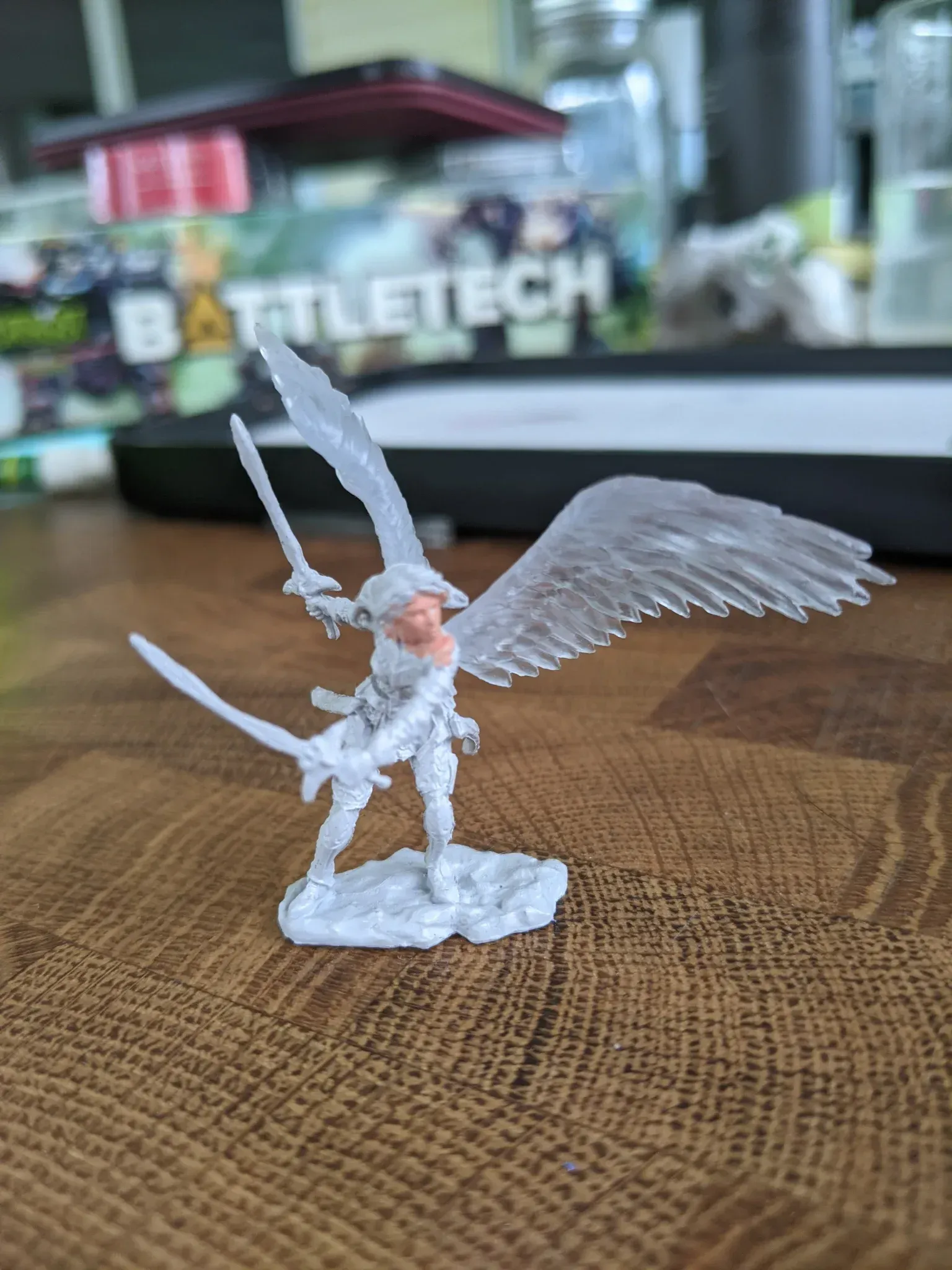 Miniature angel figure with swords and translucent wings.