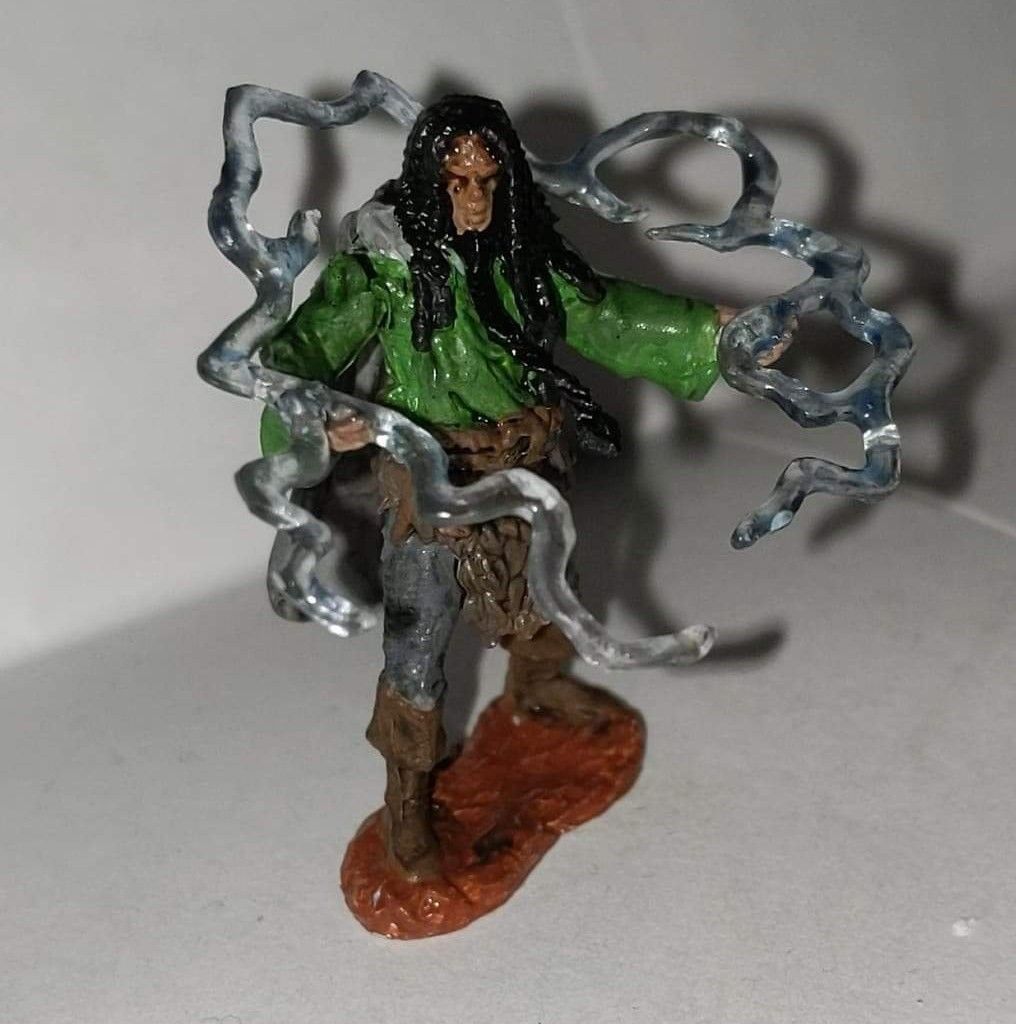 Miniature figure of a person with long hair, green jacket, and lightning effects.