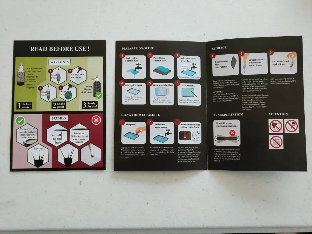 Instruction manual spread open on a white surface, with black text and diagrams in white and red.