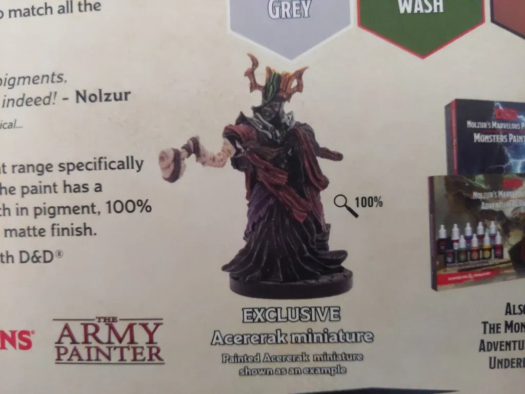 Acererak miniature, dark purple robes, holding a staff, on a product display with paint colors.