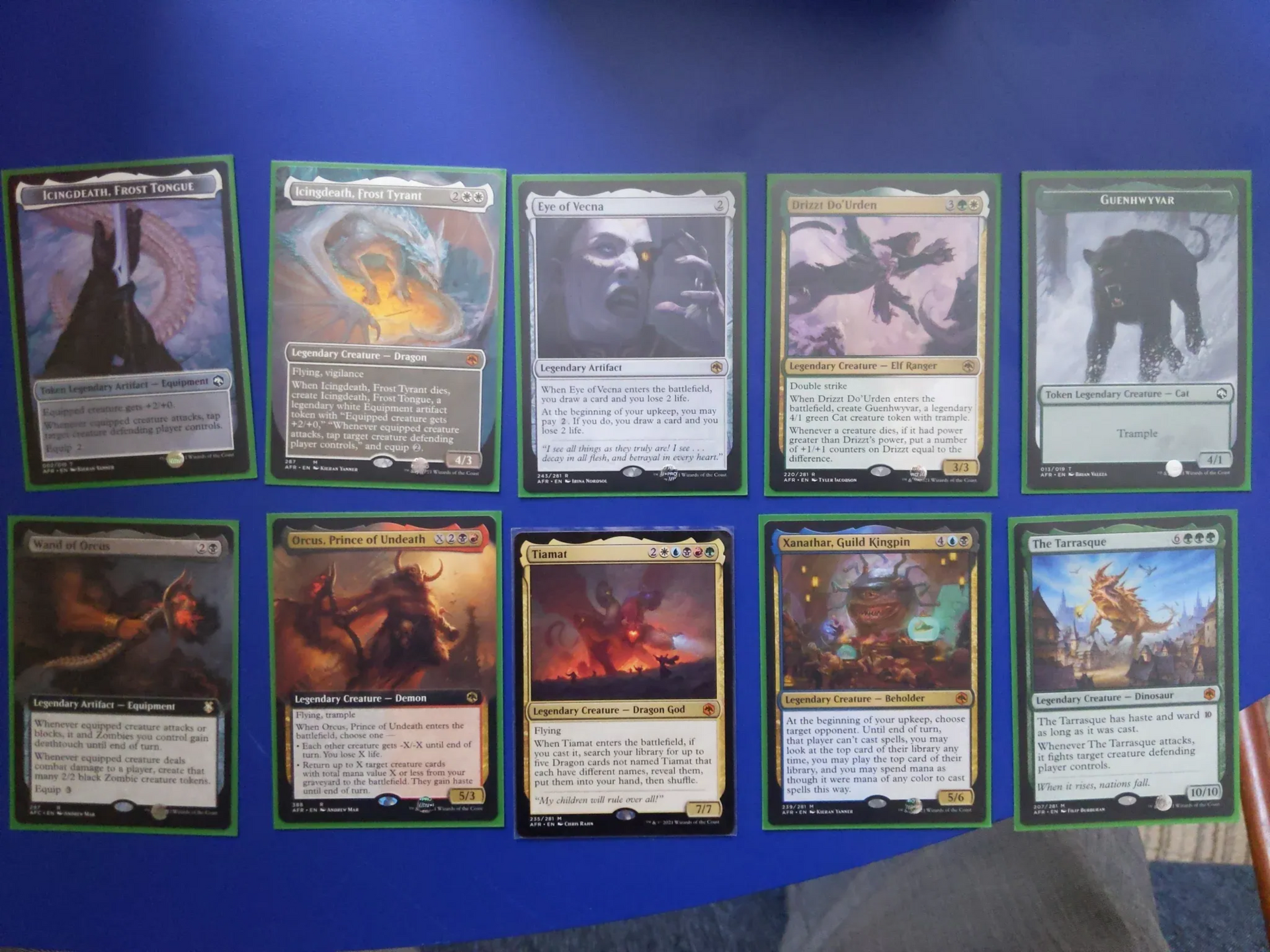 Ten Magic: The Gathering cards, various creatures/spells, on a blue surface, with green borders.