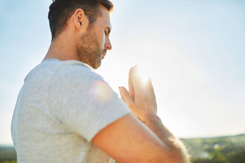 A man is meditating with his hands folded in front of him.