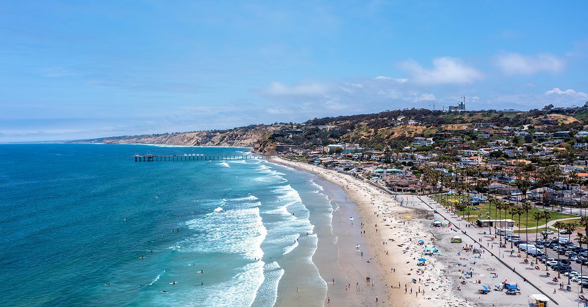 An aerial view of a beach with a lot of people on it.