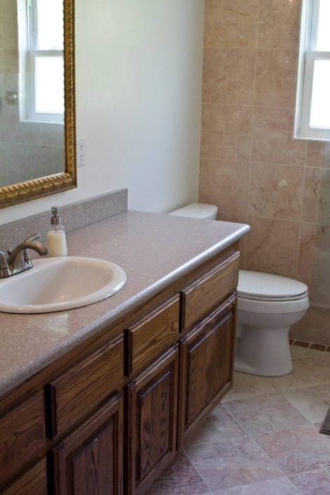 A bathroom with a sink toilet and mirror