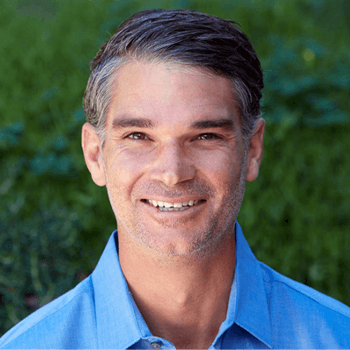 A man in a blue shirt is smiling for the camera.