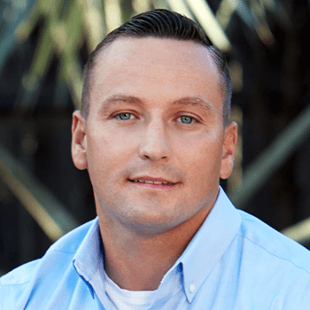 A man in a blue shirt is smiling for the camera