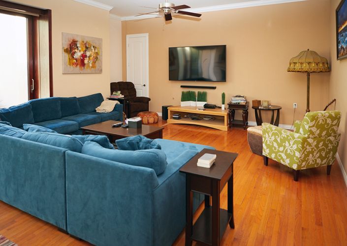 A living room with a blue couch and a flat screen tv