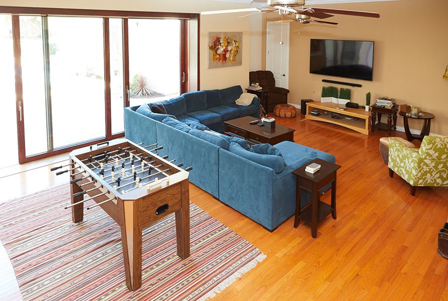 A living room with a blue couch and a foosball table