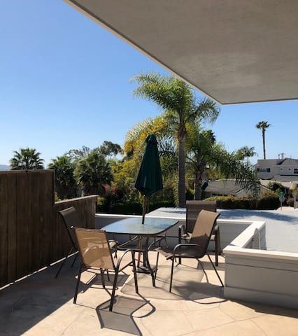A patio with a table and chairs and an umbrella